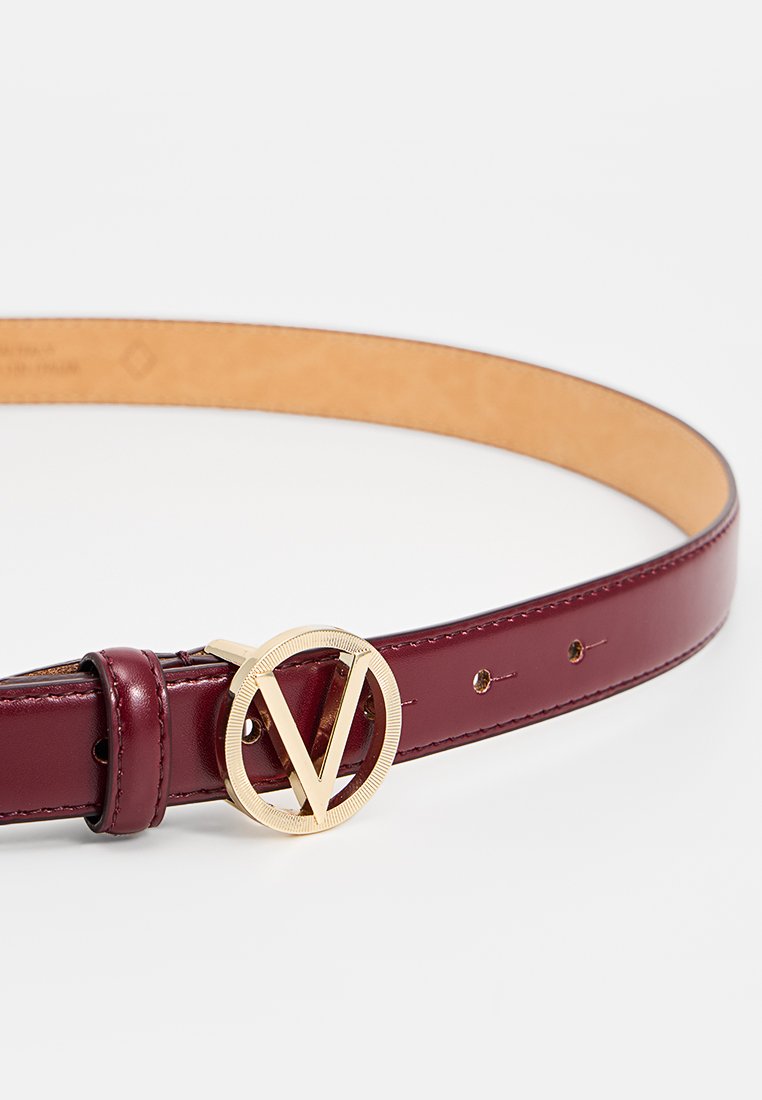 Bordeaux Leder Gürtel mit einer goldenen runden Schnalle, die ein geteiltes "V"-Design zeigt. Glatte Textur mit mehreren verstellbaren Löchern.