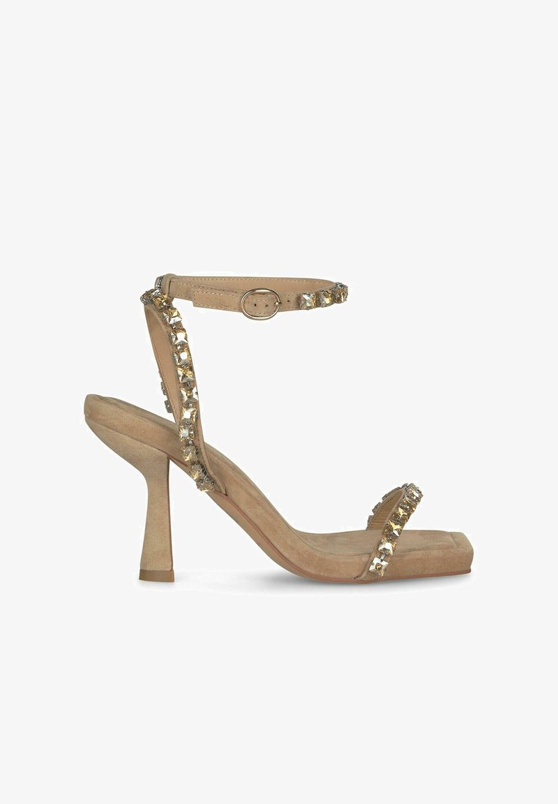 Beige High-Heelsandale mit strukturiertem Wildleder-Finish, offenem Zehenbereich und einem Knöchelriemen, der mit klaren Edelsteinen verziert ist. Blockabsatz.