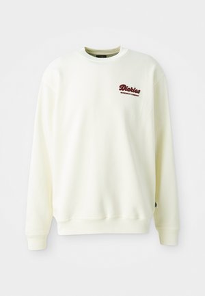 Cream-colored sweatshirt made of soft fabric, featuring a round neckline and ribbed cuffs. Displays a maroon logo on the left chest.