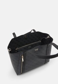 Czarna torba na ramię z wzorem logo, skórzanymi akcentami, kieszenią na zamek i solidnym uchwytem. Wnętrze wykończone kontrastową czarną tkaniną.