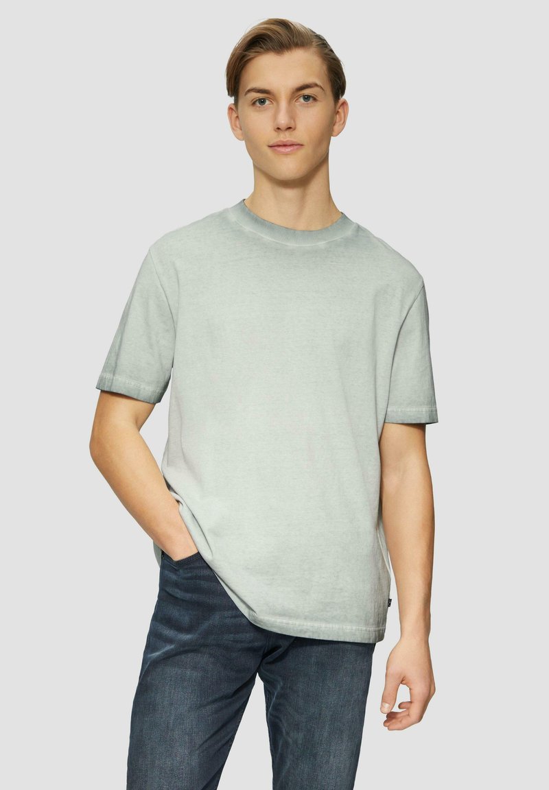 Lichtgrijs t-shirt met korte mouwen, ronde hals en een relaxed fit. Materiaal lijkt zacht met een gladde textuur. Casual ontwerp.