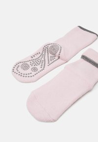 Roze pamučne čarape s teksturiranom, protivkliznom podlogom sa kružnim uzorcima. Sivi detalji na manžetni i podlozi. Mekani pleteni materijal.