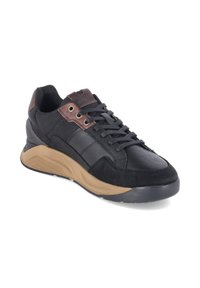 Black and brown casual sneaker with lace-up front and thick beige sole, leather and suede upper, angled view on white background.