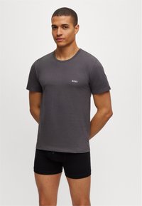 Grå bomulls t-skjorte med rund hals og korte ermer, med en liten hvit "BOSS" logo på brystet, sammen med svarte boxershorts.