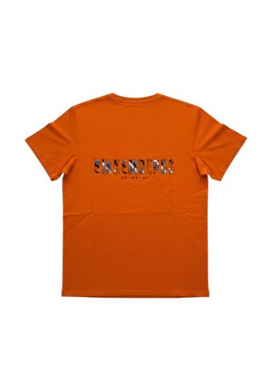 T-shirt arancione a maniche corte con la parola "BIKKEMBERGS" stampata sulla schiena in grandi lettere multicolori e testo più piccolo sotto.