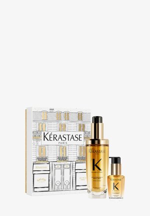 Kérastase Paris hair care set including two glass bottles with gold liquid and black pumps, displayed in a patterned white box with gold accents.