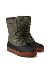 Botas verdes impermeables con puntera de goma negra y suela marrón. Presentan un diseño de cordones, un suave forro de piel y el logo de DC en el lateral.