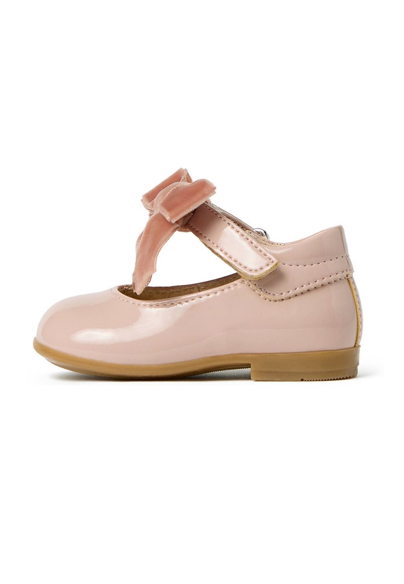 Chausson en cuir verni rose avec une pointe ronde, une sangle sur le côté et un joli nœud en velours rose doux. Texture lisse et petit talon.