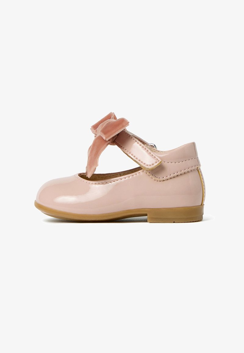 Chausson en cuir verni rose avec une pointe ronde, une sangle sur le côté et un joli nœud en velours rose doux. Texture lisse et petit talon.