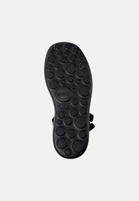 Svarte sandal såle med runde teksturerte gripe mønstre. Har en sirkulær logo og glatte kanter. Slitesterkt gummimateriale.
