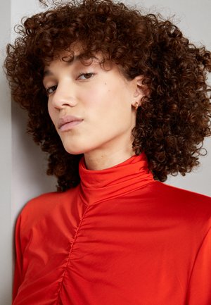 Rode hoge hals top met geplooide textuur, gladde stof en een nauwsluitende pasvorm. Heeft een minimalistisch ontwerp zonder zichtbare hardware.