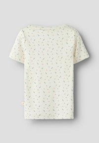 Cremefarbenes Babyshirt mit kurzen Ärmeln, rosa Blumen- und grüner Blattmuster, gerippter Textur und kleinem Etikett an der linken Seitennaht.