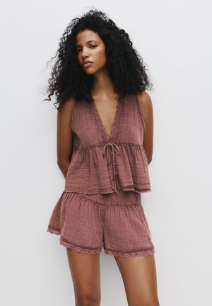 Roze-hued, lichtgewicht tweedelig lounge-outfit bestaat uit een mouwloze top met een geschulpte halslijn en een trekkoord, gecombineerd met shorts met een geschulpte zoom.