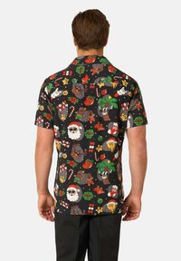 Camicia nera a maniche corte con bottoni, caratterizzata da una stampa colorata di festa con personaggi dei cartoni animati, regali, bastoncini di zucchero e alberi di Natale.