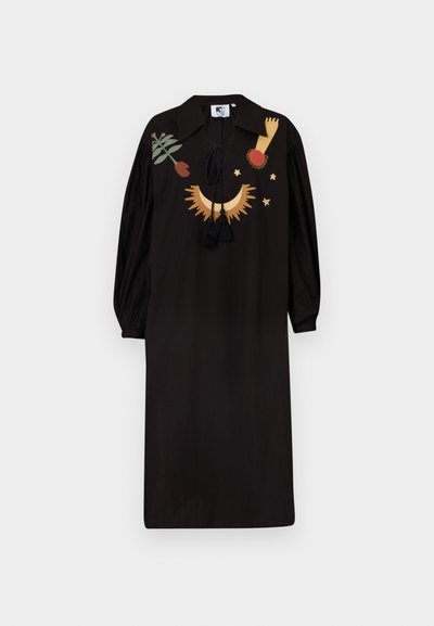 Schwarzes Kleid mit langen Puffärmel, einem Kragen und dekorativer Stickerei in Gold, Rot und Grün. Mit Quasten am Halsauschnitt.