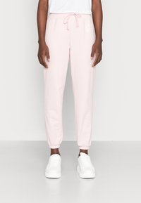 Ljusrosa joggerbyxor i mjukt tyg, med elastisk midja och dragsko, avslutade med ribbade anklar och en logodetalj på sidan.