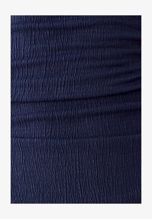 Marineblauer Stoff mit einer gerafften, strukturierten Oberfläche, die kleine vertikale Rillen aufweist und einen Rüscheffekt erzeugt.