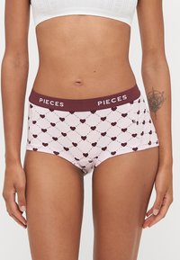 Růžové chlapčenské boxerkové šortky z bavlněného směsového materiálu s vínovým vzorem srdce, s vínovým pasem s logem "PIECES". Měkká textura, střední výška.