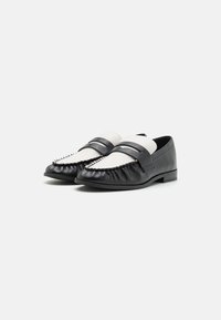 Mustad nahast loafers valge naha ribaga, koos kokku volditud varbaga, dekoratiivsete õmblustega ja lame konts.