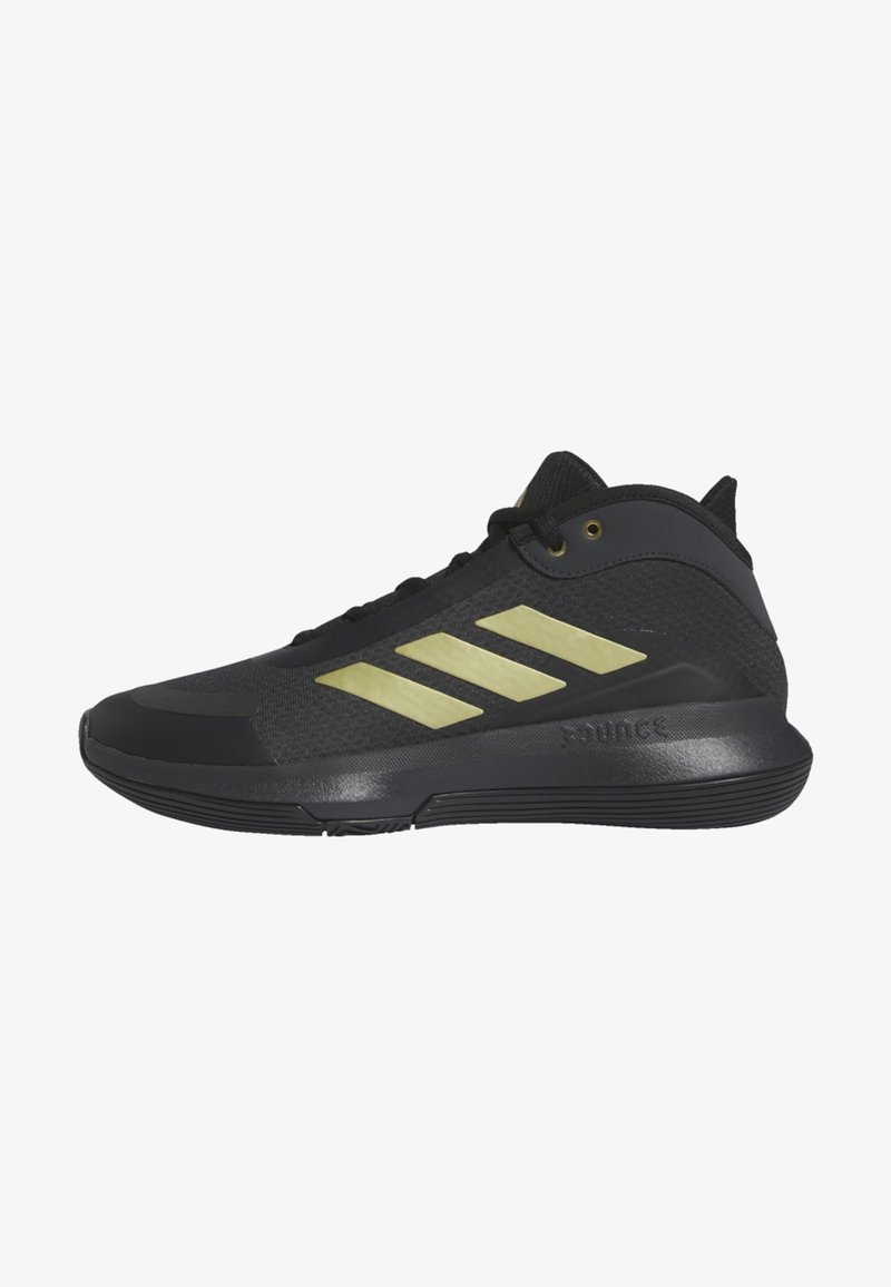 Black athletic shoes with a textured upper and three metallic gold stripes. Features a rubber sole and padded collar for support.