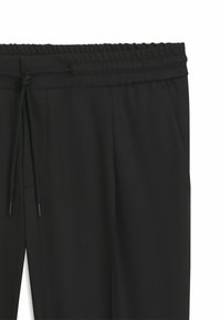 Black pants featuring an elastic waistband with a drawstring, side pockets, and a smooth, lightweight fabric texture.