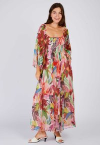 Floral maxi dress in sheer fabric, featuring smocked bodice, long sleeves, and layered skirt. Colors include red, pink, green, and blue.