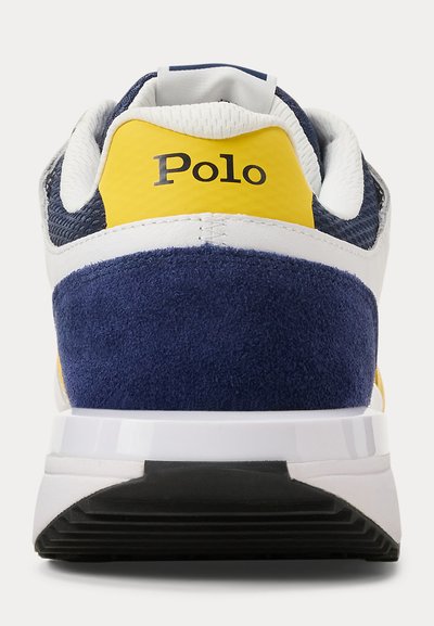 Πλάγια όψη από πίσω ενός αθλητικού παπουτσιού τύπου πόλο σε μπλε ναυτικό, κίτρινο και λευκό χρώμα, με υφή στη φτέρνα και επένδυση μαξιλαριού στον πάτο, που δείχνει τη μαύρη σόλα με πέλμα.