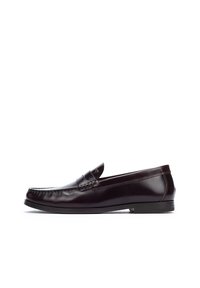 Mocasines de cuero marrón con tacón plano, punta redondeada y costuras decorativas en la parte superior. Acabado suave con acentos mínimos.