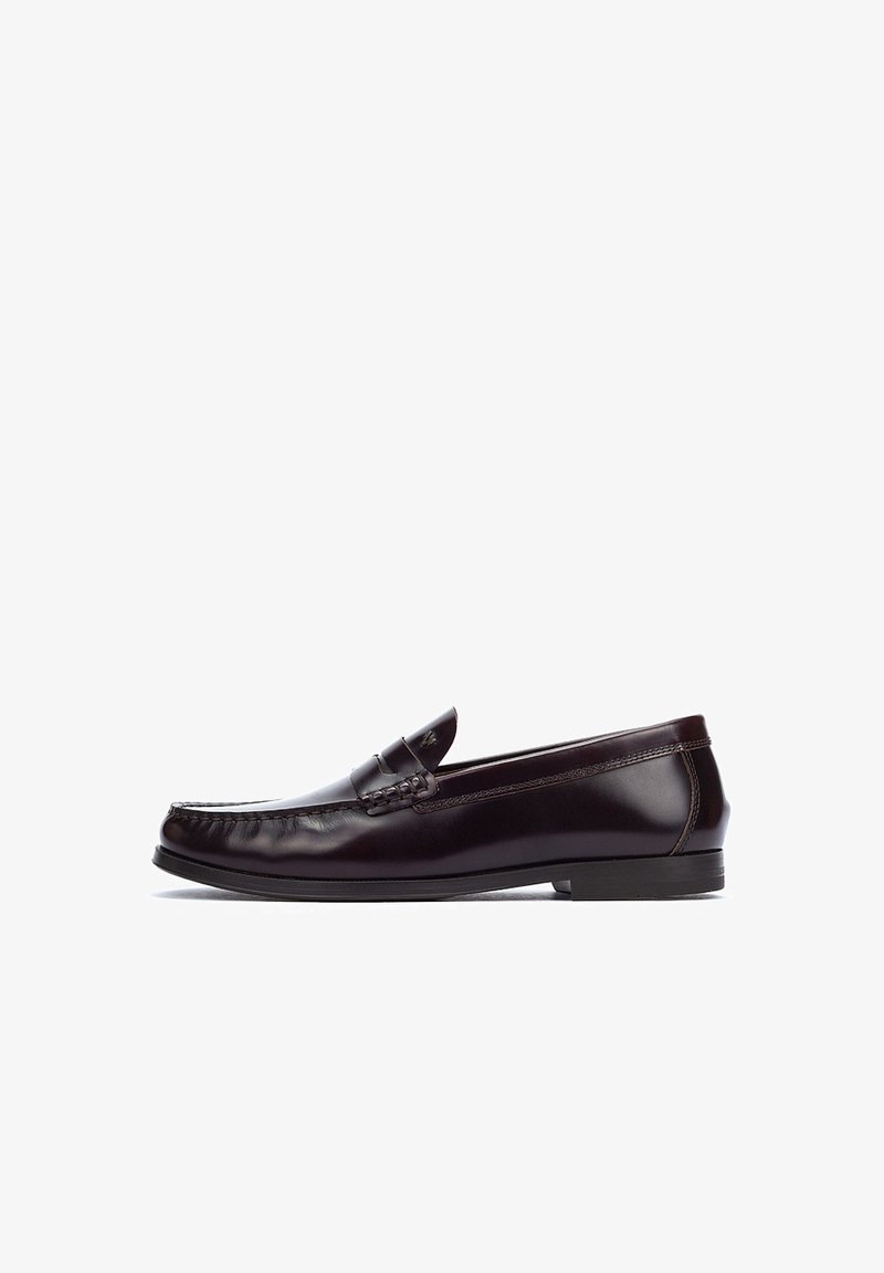 Brown leather loafers with a flat heel, rounded toe, and decorative stitching on the upper. Smooth finish with minimal accents.
