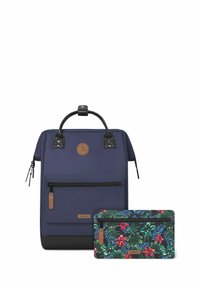 Zaino blu navy con accenti neri, dotato di tasca frontale con zip, maniglia per il trasporto e una borsa rimovibile con stampa floreale in tonalità scure.