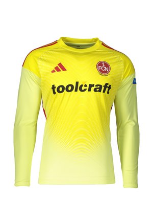 Maillot de football jaune à manches longues avec écusson rouge 1. FCN, logo Adidas rouge, texte du sponsor toolcraft et motif graphique fin sur la poitrine.