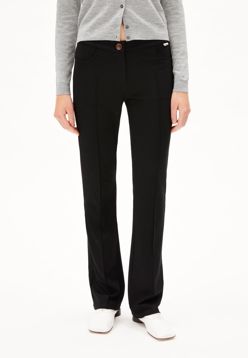 Zwarte op maat gemaakte broek met een gladde textuur, voorzien van een knoopsluiting, zijzakken en subtiele plooidetails langs de benen.