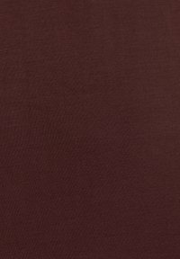 Bordeauxfarbener Stoff mit glatter Textur und feinem Strickmuster, das eine gleichmäßige, konsistente Farbe aufweist, ohne sichtbare Variationen.