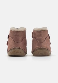 Růžové dětské boty z semiše s měkkým, huňatým límcem, nastavitelným popruhem a strukturovanou gumovou podrážkou se švy.