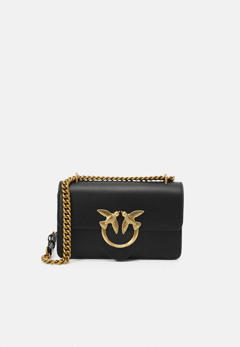 Borsa a tracolla in pelle nera con catena dorata e una chiusura decorativa con due motivi di uccelli. Forma rettangolare con superficie liscia.