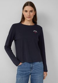 Marineblaue Langarm-T-Shirt mit Rundhalsausschnitt und einem kleinen roten gestickten Design, das "Bonjour Mon Amour" liest. Weicher, lässiger Schnitt.