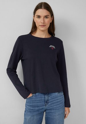 T-shirt à manches longues bleu marine avec un col rond et un petit motif brodé rouge qui dit "Bonjour Mon Amour". Taille douce et décontractée.
