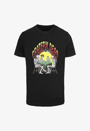 Musta musta t-paita, jossa on värikäs kuva luurangoista pöydän äärellä, designissa lukee "GRATEFUL DEAD" ja mukana on ruusuja.