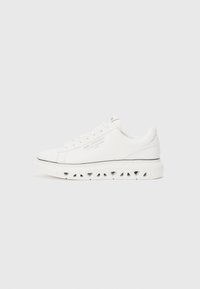 Witte sneakers met een gladleren bovenkant, geperforeerde zool en zwarte accentlijn. Voorzien van een ronde neus en platte vetersluiting. Minimalistisch ontwerp.
