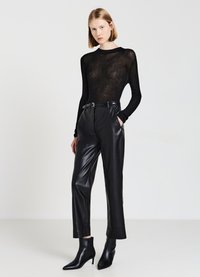 Top nero trasparente a maniche lunghe con texture a coste abbinato a pantaloni in pelle nera a vita alta e stivaletti a punta.