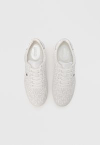 Baskets blanches en tissu texturé avec un motif subtil de logo, bout arrondi, design à lacets et accents métalliques sur le talon.