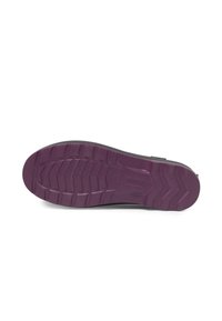 Chaussures noires avec une semelle texturée en violet profond, dotées d'un motif de crampons robuste et d'un talon légèrement surélevé pour plus de stabilité.