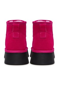 Ghetele ankle din suede fuchsia cu o talpă din cauciuc negru neted, având vârful rotunjit și un detaliu texturat pe laterale. Tab-ul de călcâi întărit pentru o purtare ușoară.