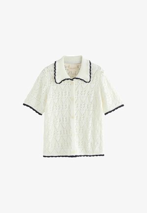 Weißer Kurzarm-Strick-Cardigan mit Knopfleiste, schwarz gewelltem Besatz am Kragen, an den Bündchen und am Saum, mit einem Rautenspitzenmuster.