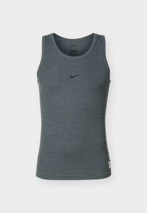 Maiou sport gri închis fără mâneci, cu un mic logo negru Nike Swoosh centrat pe piept și o etichetă aproape de tivul inferior.