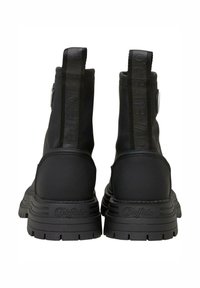 Czarne botki za kostkę z gładką cholewką, wytłoczonym detalem z logo, tylną pętelką oraz grubą gumową podeszwą z wyraźnym wzorem bieżnika.