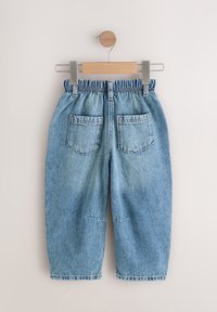 Jasnoniebieskie spodnie z denimu z elastycznym pasem, dwoma tylnymi kieszeniami i luźnym krojem. Charakteryzują się postrzępionymi brzegami i klasycznym przeszyciem.