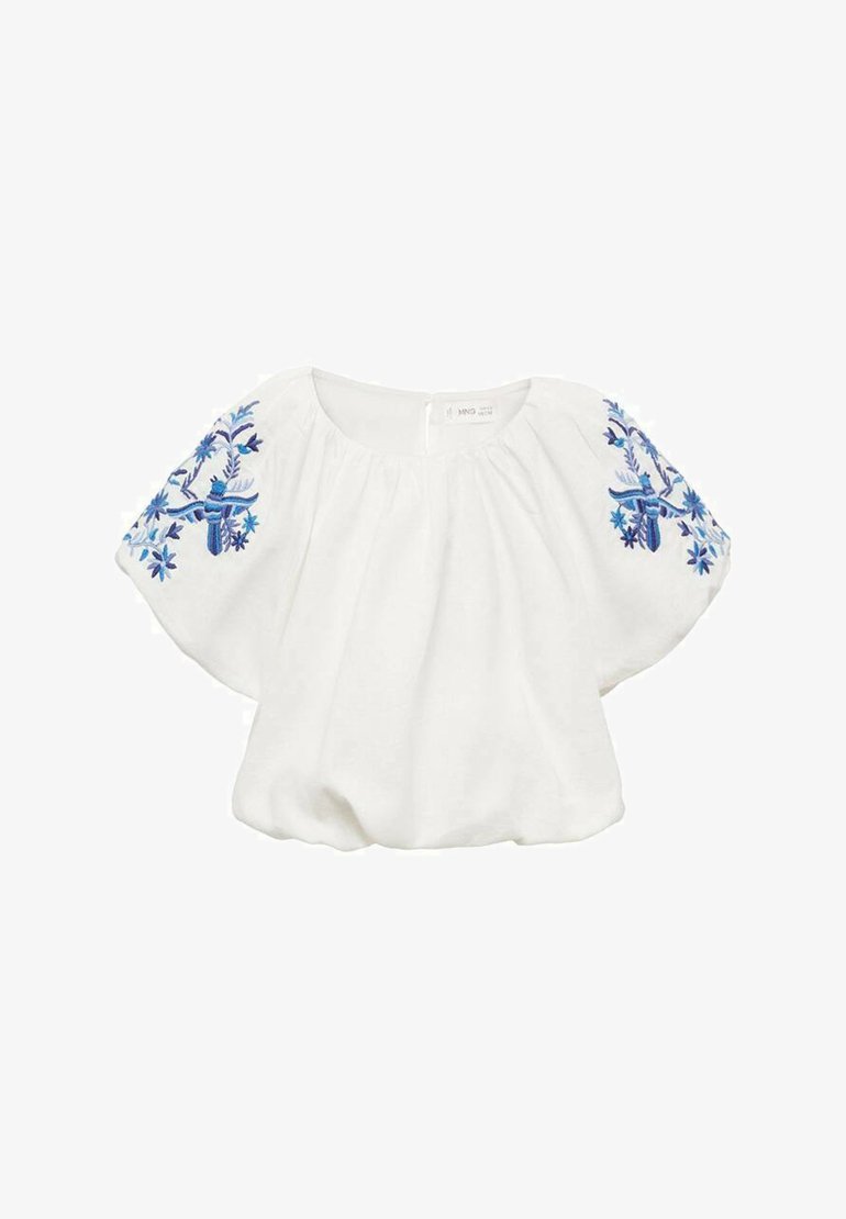 Bela bluzica s kratkimi, širokimi rokavi. Na rokavih je modra cvetna vezenina. Mehka, lahka tkanina s sproščenim krojem.