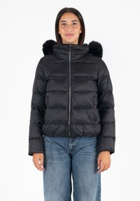 Giacca a soffietto nera con zip frontale, colletto alto e cappuccio in pelliccia sintetica removibile. Realizzata in un materiale lucido con un design trapuntato.