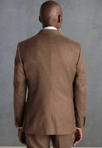 Brown wool suit jacket with a smooth texture, featuring a tailored fit and notch lapels. Includes black buttons and a vented back.